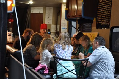 John Welker in a red fez leading a game